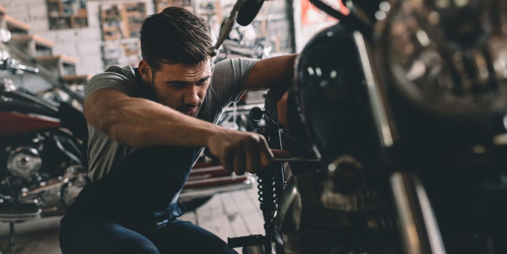 Mechanic checking over a Motorcycle during its MOT